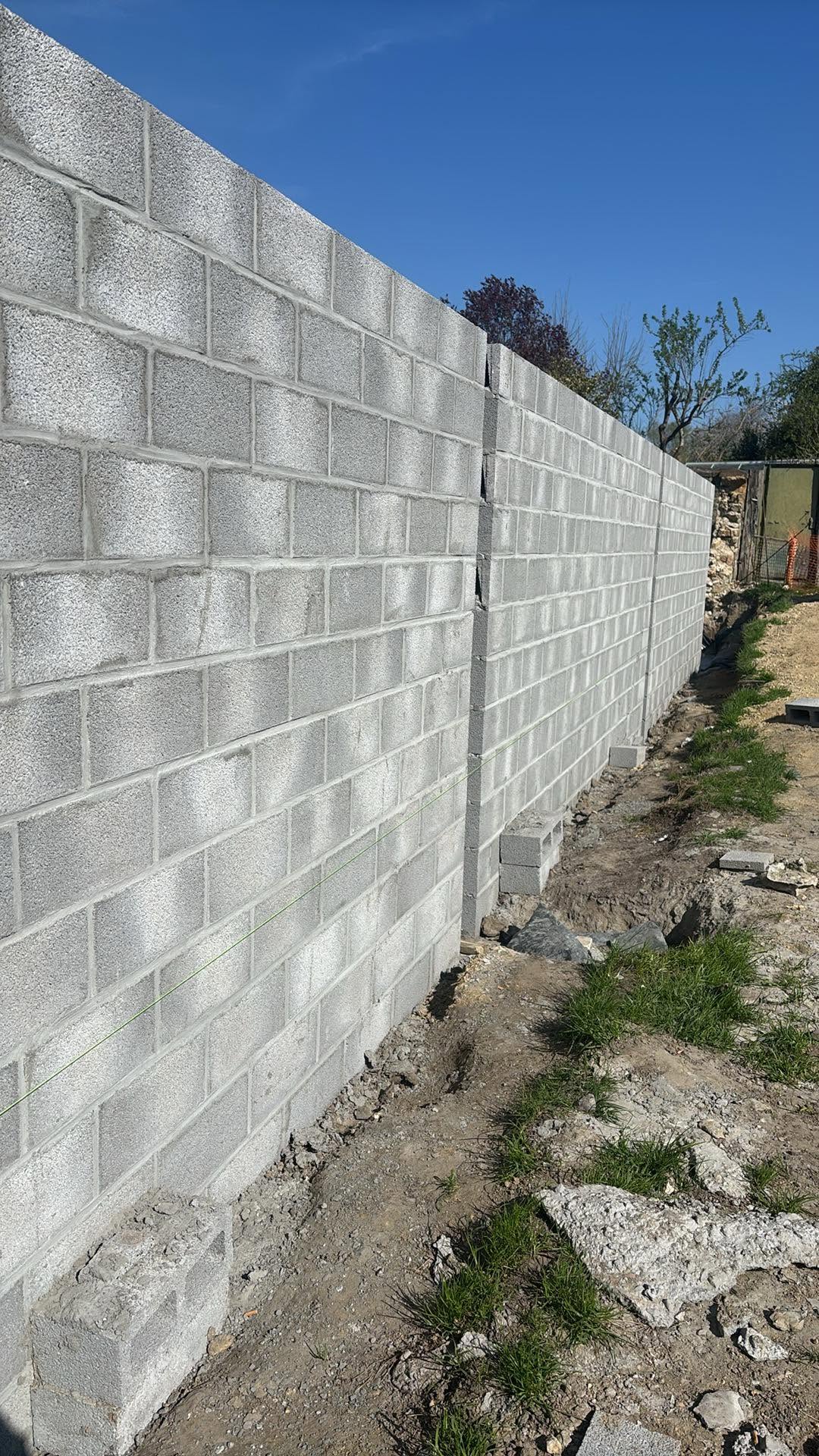 Mur en blocs béton avec tranchée et abords non remis en état